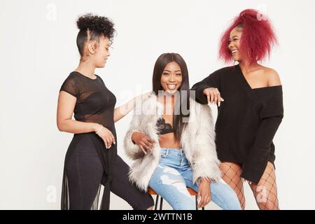 Tre donne in posa insieme in abiti eleganti. Foto Stock