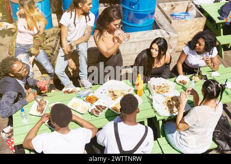 Gruppo di amici gustando un pasto all'aperto Foto Stock