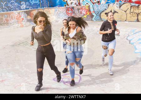 Gruppo di donne che si divertono in un luogo coperto di graffiti Foto Stock