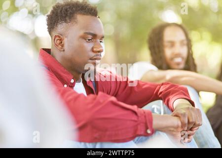 Un uomo nel profondo del pensiero con un'altra persona sullo sfondo Foto Stock