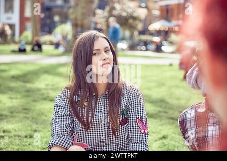 Donna in un parco che parla con un amico Foto Stock