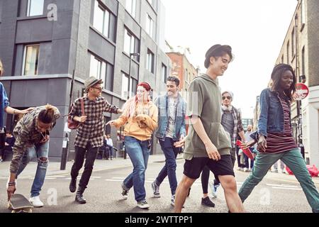 Gruppo di amici che camminano lungo una strada della città Foto Stock