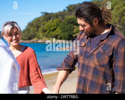 Due persone che stringono la mano vicino al mare Foto Stock