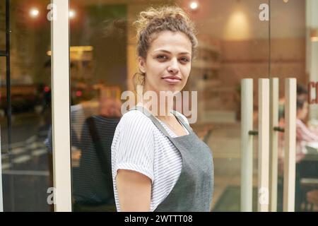 Donna in piedi davanti a una finestra di vetro Foto Stock