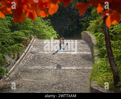 Fotografo che cattura un momento su un ponte di ciottoli Foto Stock