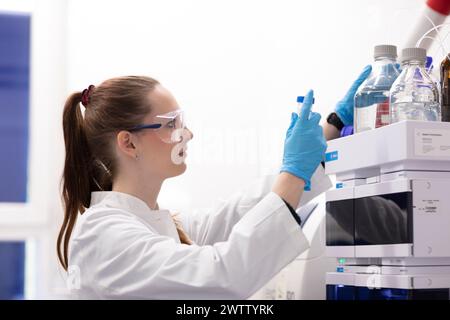 Scienziato specializzato che opera attrezzature da laboratorio. Foto Stock