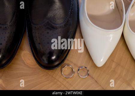 Un'elegante scarpa da sposa e sposo con anelli che simboleggiano l'unità Foto Stock