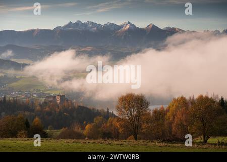 Panorama autunnale con alberi colorati di Czorsztyn, Polonia. Castello vecchio e monti Tatra dietro, Pieniny e nebbia in primo piano. Foto Stock