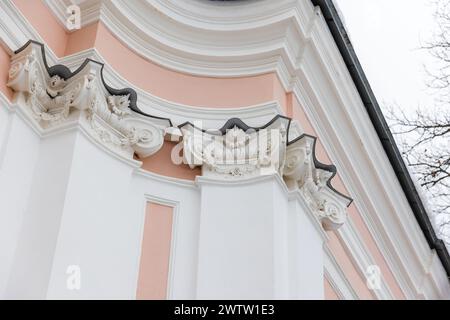 Portico classico con dettagli rosa e bianchi sotto il cielo luminoso. Pilastri e angoli Foto Stock