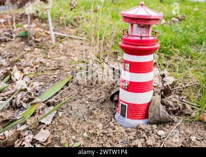 faro. faro giocattolo rosso e bianco su sfondo naturale. All'inizio della primavera Foto Stock