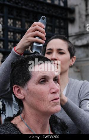 Londra, Inghilterra, Regno Unito. 19 marzo 2024. Una manifestante si rasa i capelli osservata dai colleghi fuori dalla camera del Parlamento. Le donne manifestanti si stanno radendo la testa a sostegno delle donne di Gaza. (Credit Image: © Joao Daniel Pereira/ZUMA Press Wire) SOLO PER USO EDITORIALE! Non per USO commerciale! Foto Stock