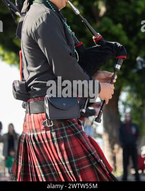 Suonatore di pipa che indossa un kilt in onore della tradizione irlandese durante la parata del giorno di San Patrizio. Foto Stock