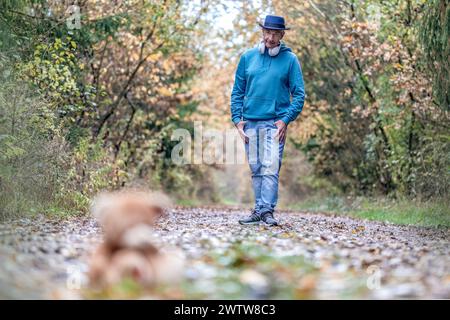 Un uomo migliore che calci un orsacchiotto in una foresta in autunno all'aperto Foto Stock