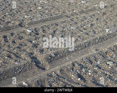 Sfregamento nella sabbia. Tracce delle ruote delle auto sulla spiaggia. Sabbia e pietre. Concetto di guida fuoristrada Foto Stock