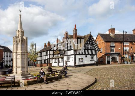 Antica piazza del mercato acciottolato nella città di Sandbach nel Cheshire con il monumento alla guerra in primo piano e il vecchio pub Black Bear sullo sfondo Foto Stock