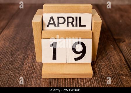19 aprile. Immagine del calendario in legno del 19 aprile su sfondo bianco. Giorno di primavera, spazio vuoto per il testo. Il giorno di Snowdrop Foto Stock