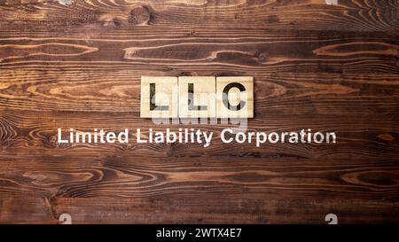 Una riga di cubi di legno con testo LLC, acronimo di Limited Liability Company. Concetto di business Foto Stock