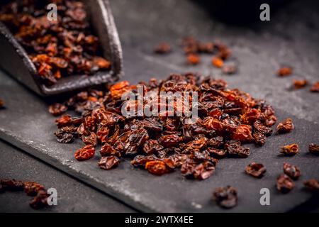 Berberi secchi organici e paletta su terreno nero Foto Stock