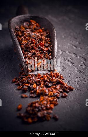 Berberi secchi organici e paletta su terreno nero Foto Stock