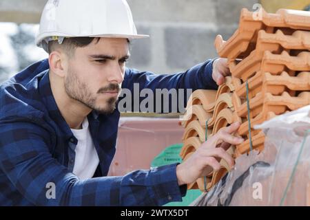 Builder lavorando sul tetto del nuovo edificio Foto Stock