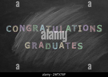 Testo per disegnare a mano COMPLIMENTI DIPLOMATI sulla lavagna. Foto Stock