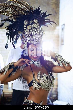 Ballerina, samba e spettacolo con festa, sorriso e trucco per concerto o festa. Donna brasiliana, festival e piume per cultura, talento e.. Foto Stock