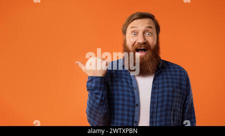 uomo con barba elegante che punta il pollice con eccitazione a parte, studio Foto Stock