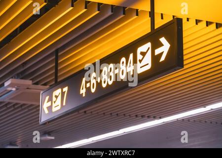 Indicazioni per i numeri di gate per i cancelli d'imbarco all'interno del terminal dell'aeroporto. Foto Stock