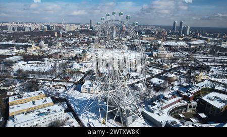 Vista dall'alto della grande ruota panoramica in inverno. Creatività. Splendido paesaggio urbano con ruota panoramica nel centro della città in inverno. Ruota panoramica al centro della grande Foto Stock