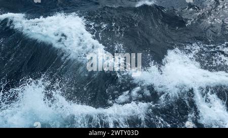 Bellissime onde da una barca in movimento. Fermo. Spruzzi di onde da una barca in movimento. Bellissime onde che si muovono lateralmente da una barca galleggiante in mare Foto Stock