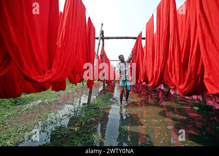 I lavoratori del Bangladesh raccolgono i tessuti dopo averli asciugati sotto il sole in una fabbrica di tintura a Narayanganj, vicino a Dacca, Bangladesh, il 20 marzo 2024. Foto di Habibur Rahman/ABACAPRESS.COM Foto Stock