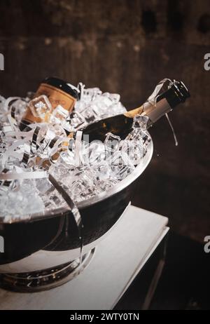 Bottiglie di champagne in secchio di ghiaccio con carta grattugiata Foto Stock