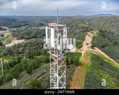 Vista aerea con drone di GSM, 4G, 5G e torri di telecomunicazione radio sulla cima di una montagna. Torre del telefono cellulare e stazione ricetrasmittente. Trasmissione antenna Foto Stock