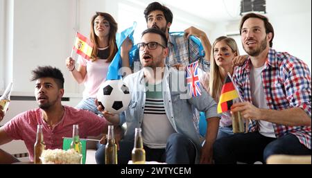 Amici sconvolti e frustrati che guardano la partita di calcio a casa Foto Stock