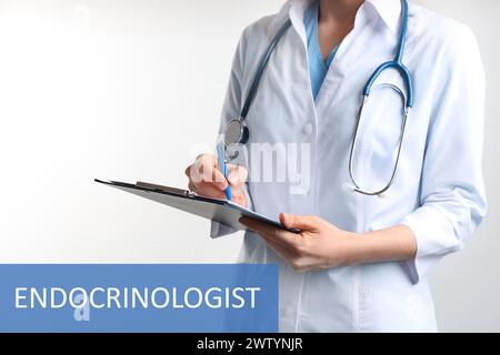 Endocrinologo con stetoscopio, appunti e penna su sfondo bianco, primo piano Foto Stock