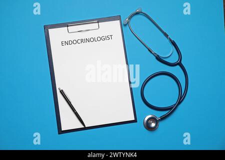 Endocrinologo. Appunti, stetoscopio e penna su sfondo azzurro, vista dall'alto Foto Stock