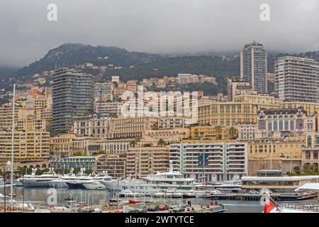 Monaco - 2 febbraio 2016: Yacht ormeggiati a Port Hercules Cityscape View Cold Winter Day Clouds Over Mountains. Foto Stock