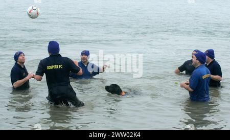 01/01/11..Un labrador dello spettatore si unisce al divertimento e ruba una partita di calcio dai giocatori del Gosport Football Club che si sono Uniti a più di 200 nuotatori in un unico gioco Foto Stock