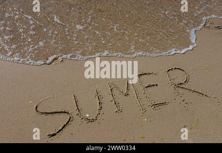 L'iscrizione sulla sabbia Estate simboleggia una vacanza estiva al mare. Foto Stock