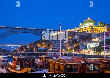 Portogallo, Porto, quartiere di Ribeira; guardando attraverso il fiume Douro di notte verso Vila Nova de Gaia e il ponte Luís I. Foto Stock