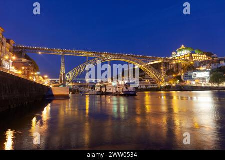 Portogallo, Porto, quartiere di Ribeira; guardando attraverso il fiume Douro di notte verso Vila Nova de Gaia e il ponte Luís I. Foto Stock