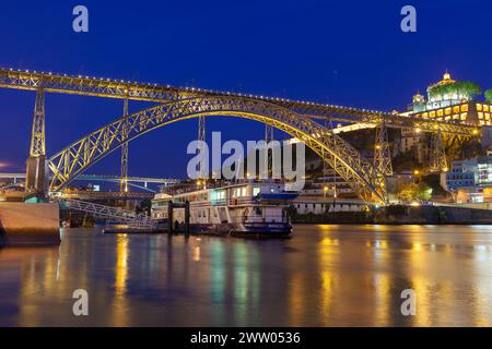 Portogallo, Porto, quartiere di Ribeira; guardando attraverso il fiume Douro di notte verso Vila Nova de Gaia e il ponte Luís I. Foto Stock