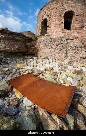 Resti di una vecchia fabbrica di mattoni abbandonata a Porth Wen, sulla costa settentrionale di Anglesey, nel Galles del Nord. Foto Stock