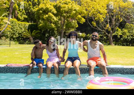 Una famiglia afroamericana ama una giornata di sole in piscina Foto Stock