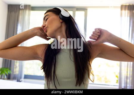 Una giovane donna bruna asiatica si gode una pausa con la musica a casa Foto Stock