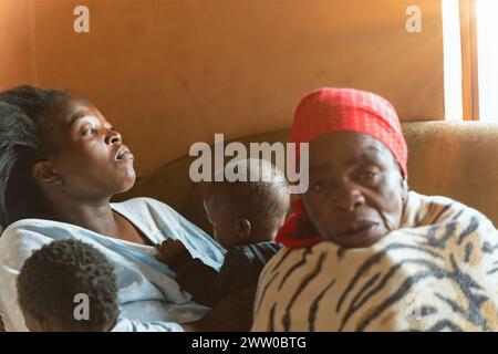 Famiglia africana del villaggio di tre generazioni, all'interno di una casa cittadina a Soweto Foto Stock