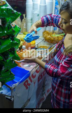 Donna messicana che prepara un mais bollito, tipico cibo di strada messicano. Stallo di cibo. Elote. Foto Stock