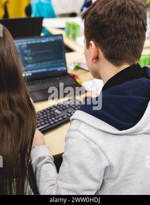 Studenti di sviluppatori di software in auditorium che lavorano su computer e laptop, concorso di programmazione hackathon, pc con app per programmi di codifica, Foto Stock