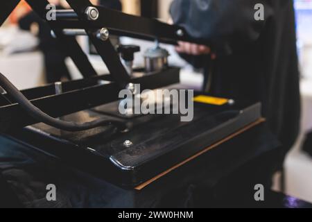 Processo di stampa dell'immagine su abiti, stampa a caldo su t-shirt e felpa con cappuccio in officina di tessuti, maglietta serigrafica, texti Foto Stock