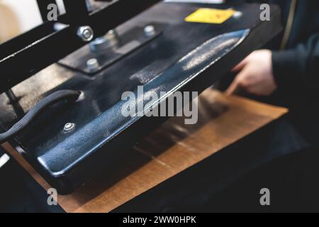 Processo di stampa dell'immagine su abiti, stampa a caldo su t-shirt e felpa con cappuccio in officina di tessuti, maglietta serigrafica, texti Foto Stock